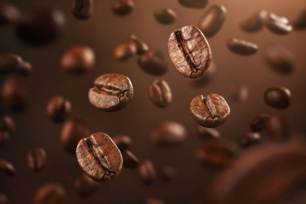 kaffebönor som faller med brun bakgrund